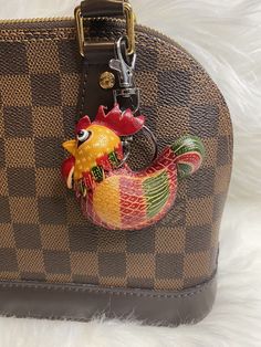 a handbag with a rooster on the handle