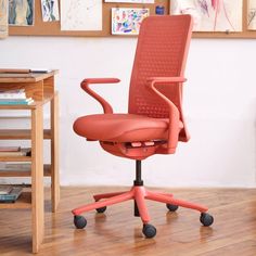 an orange office chair sitting on top of a hard wood floor