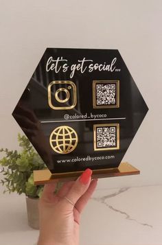 a person holding up a black and gold plaque with the words get's get social on it