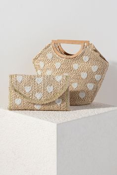 Add some sweetness to your summer accessories with Shiraleah's Hearts Mini Tote. Made from natural woven jute with a sturdy half-circle top handle, it is a classic neutral bag to go with any outfit or occasion. Its elegant beaded heart design will never go out of style. Pair with other Shiraleah items to complete your look! Features a top handle and elegant beaded heart design Shiraleah is a trend-driven lifestyle brand focused on the little gifts that make life special! Made from jute Measures Heart-shaped Summer Bag For Everyday Use, Heart-shaped Summer Bags For Everyday Use, Heart-shaped Bags For Everyday Spring Use, Heart-shaped Spring Bags For Everyday Use, Heart-shaped Spring Bags For Everyday, Heart-shaped Everyday Bags For Spring, Circle Top, Heart Clutch, Neutral Bag