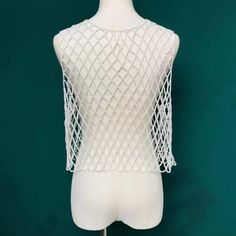 a mannequin with white knitted clothing on it's head and torso