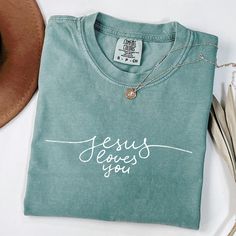 *If you would like a colour or size that is not listed, please contact us. Embrace your faith and purpose with our "Jesus Loves You" Christian t-shirt! This stylish and meaningful graphic tee is a perfect reminder that you are destined for greater things. Whether you're heading to church, a Bible study group, or just out for the day, this shirt speaks to your values and faith. ✨ Features: High-Quality Fabric: Soft, breathable cotton blend for ultimate comfort. Faith-Inspired Design: The bold "Ma Christian Outfits, Christian Clothes, Clothing Board, Christian Shirts Designs, Christian Merch, Decal Ideas, Plus Size Shirt, Teen Outfits, Bible Study Group