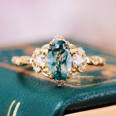 Celebrate your love story with the enchanting Esme Moss Agate Engagement Ring. Expertly crafted from 14K Solid Yellow Gold, this ring showcases an exquisite oval-cut moss agate, embodying timeless elegance and exceptional brilliance.►The design draws inspiration from fairy-core vintage aesthetics, making it a perfect piece for those who appreciate the charm of yesteryear combined with modern sophistication. The intricate detailing and romantic allure of the Esme ring make it an ideal choice for Fairy Ring, Moss Agate Engagement Ring, Agate Engagement Ring, Green Moss Agate, Heart Flutter, Vintage Aesthetics, Moss Agate Ring, Fairy Core, Agate Ring