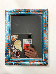 a person taking a selfie in front of a mirror with stickers on it