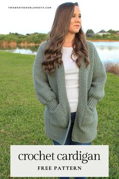 a woman standing in the grass wearing a cardigan