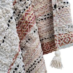 several knitted shawls with tassels hanging from them