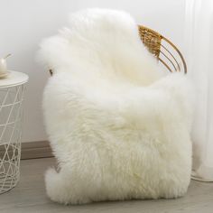 a white chair sitting on top of a hard wood floor next to a table and window