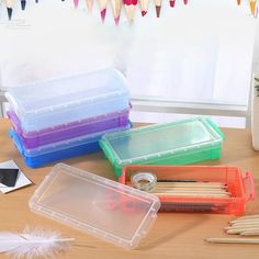 several plastic containers with pencils and pens on a table