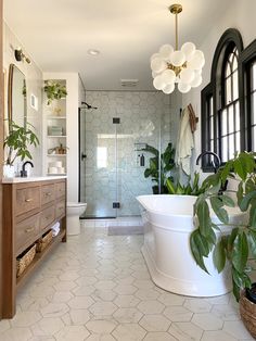 a bathroom with a tub, sink and large mirror on the wall next to it