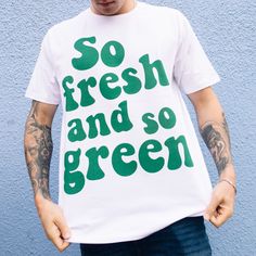 Super fresh.  Printed t-shirt by Batch1 Slogan to front: "So Fresh And So Green" in 70s style typography Print: Organic, water-based, eco-friendly ink Style: Crew neck, short sleeves, soft jersey Fit: Relaxed, Unisex Size Guide (chest to fit):  S - 34/36" | M - 38/40" | L - 42/44" | XL - 46/48" | XXL - 50/52" Model wears size Extra Large  Material: 100% organic cotton Sustainability: Ethically made to order in the UK  | Global Organic Textile Standard | Fair Wear | Vegan  Care: Machine wash Cheap Green Graffiti Print T-shirt, Cheap Green T-shirt With Graffiti Print, Unisex Retro T-shirt With Text Print, Organic Cotton Graphic Tee With Text Print, Green T-shirt For Streetwear, Unisex Green Screen Print T-shirt, Eco-friendly Green Cotton T-shirt, Organic Short Sleeve T-shirt With Screen Print, Green Short Sleeve Eco-friendly T-shirt