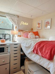 a white bed sitting next to a window with lots of pillows on top of it