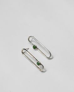 Asymmetrical oblong loop earrings, set with delicate round jade stones. Hand carved in wax and then cast in brass or sterling silver. Earrings measure 1 3/4" by 3/8". Sterling silver posts and backs. Availability: Made to order, ships in 2-4 weeks. Need it sooner? Please don't hesitate to get in touch and we'll do our best to accommodate. Modern Green Earrings With Polished Finish, Modern Oblong Single Earring Jewelry, Modern Oval Jade Jewelry, Modern Oblong Sterling Silver Earrings, Modern Sterling Silver Oblong Earrings, Loop Earrings, Coral Gables, Pop Bottles, Jade Stone