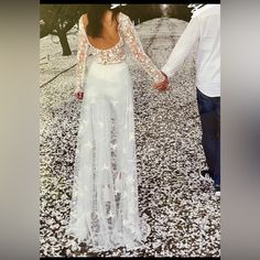 a woman in a white dress holding hands with a man