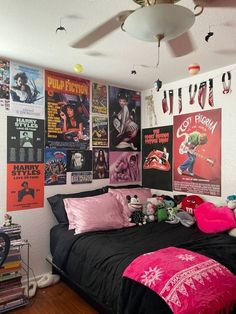 a bed room with a neatly made bed and lots of posters on the wall above it