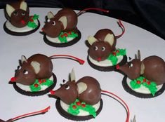 there are chocolate mice on top of cupcakes with candy sticks in the shape of antlers