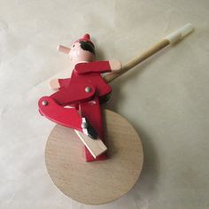 a toy baseball player on top of a wooden base with a bat in his hand