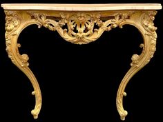 an ornately carved console table against a black background