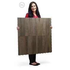 a woman holding up a large piece of wood