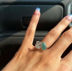 a woman's hand with a ring on it in front of a car door