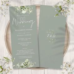 the wedding program is displayed on top of a plate with flowers and greenery around it