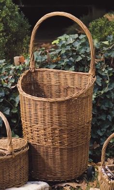 three wicker baskets sitting next to each other in front of bushes and shrubbery