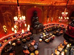 the interior of a fancy restaurant with chandeliers and large buddha statue in the center