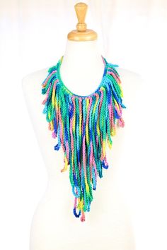 a white mannequin with a multicolored necklace on it's neck