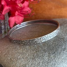 This is a beautiful Sterling Silver, mid-century bangle bracelet with a floral pattern.  Excellent vintage condition. Circumference: 7.8"  Width: .25"  Inner Diameter: 2.5"  Additional Information: * Complimentary Gift Wrap!  * All jewelry items come securely packaged and are mailed promptly upon payment - often same-day.  * The majority of my vintage items are used and may show some wear. Please review all photos closely.  * All measurements are approximate.  * If you want to save this item for Ornate Stamped Bangle Bracelet, Vintage Bangle Bracelets For Wedding, Elegant Round Stamped Bracelets, Elegant Stamped Bracelet, Vintage Etched Bangle For Wedding, Vintage Hinged Bracelets For Wedding, Vintage Hinged Bangle For Formal Occasions, Vintage Engraved Bangle Bracelets, Elegant Stamped Bangle Bracelet