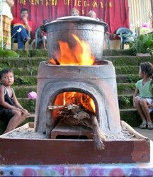 two children sitting in front of an open fire pit on the steps to a building