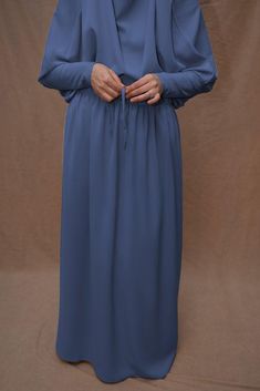 Introducing Blue Moira Prayer Umrah Gown with Niqab Feature from Annah Hariri. This beautiful gown is made from high-quality Nada abaya fabric and features super light, stretchy jersey sleeves for ultimate comfort. The elasticated waistband and full skirt ensure a flattering and secure fit, while the khimar can be tied at the back of the head for added coverage.But the best part? This gown can also be transformed into a niqaab with just a few simple stitches. So whether you're performing Umrah, Traditional Blue Hijab For Eid, Modest Blue Niqab For Eid, Long Blue Khimar For Eid, Blue Long Khimar For Eid, Blue Modest Khimar For Eid, Blue Modest Long Abaya, Modest Solid Color Niqab, Modest Blue Dresses For Eid, Blue Dabka Maxi Length Abaya