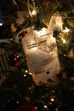 an ornament hanging from the top of a christmas tree with lights on it