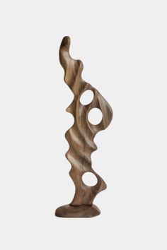 a wooden sculpture on a white background with an abstract design in the shape of a wave