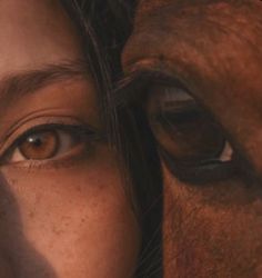 a close up of a woman's face next to a brown horse