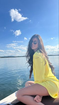 a woman sitting on top of a boat in the water