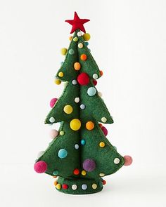 a small green christmas tree with multi colored balls on it's bottom and a star on top