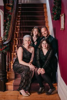 a family sitting on the stairs at christmas time