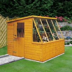 a small wooden shed with plants growing inside