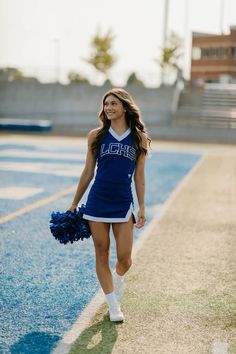 a female cheerleader is walking on the field