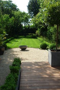 a wooden walkway leading to a lush green yard