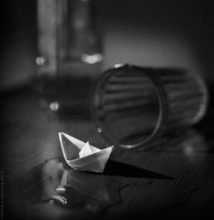 an origami boat sitting on top of a wooden table