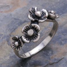 Daisies cast their shadow on a silver band. Presented by Thailand's Wadarat Supasirisuk this lovely ring is lighthearted and modern. .925 Sterling silver Delicate Silver Ring For Spring, Adjustable Flower Ring For Spring Anniversary, Adjustable Sterling Silver Ring For Spring, Spring Anniversary Adjustable Flower Ring, Delicate Adjustable Silver Flower Ring, Silver Flower Rings With Adjustable Fit, Vintage Rings For Spring Gift, Adjustable Silver Flower Ring, Vintage Adjustable Flower Ring For Spring