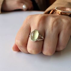 Experience the understated elegance of our Prehnite ring, meticulously handcrafted in sterling silver. This exquisite piece showcases a genuine Prehnite gemstone, known for its soothing green hue and calming energy. The delicate silver setting complements the stone's natural beauty, making it a perfect accessory for any occasion. Embrace the subtle charm of nature with this unique, artisanal ring, designed to adorn your fingers with timeless grace and sophistication. The gemstone is a OVAL shape Modern Oval Cabochon Opal Ring As Gift, Elegant Sterling Silver Crystal Ring With Oval Cabochon, Elegant Handmade Green Moonstone Ring, Handmade Elegant Green Moonstone Ring, Green Oval Prehnite Rings, Moonstone Oval Cabochon Ring, Delicate Oval Sterling Silver Rings, Elegant Handmade Moonstone Stackable Rings, Handmade Elegant Moonstone Stackable Rings