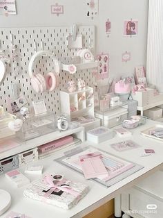 a desk with lots of pink and white items on it's sides, including books