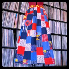 a dress made out of patchwork material is displayed in front of a record collection