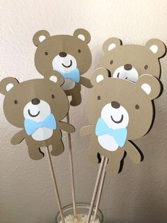 there are some brown teddy bears on sticks in a glass vase with straws inside