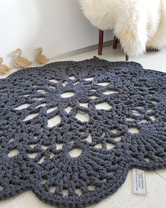 a crocheted rug on the floor next to a stuffed animal