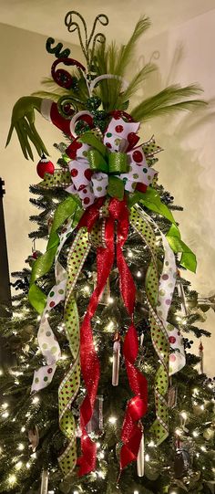 a christmas tree decorated with red, white and green ribbons