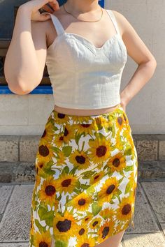 Your next favorite statement piece. Two subtle slits at the front add light detail to the summer mini skirt. A hand painted sunflowers print adorn the skirt. With warm yellow shades emanating bright, cheerful vibes, it's hard not to love this little number. The beautifully hand-painted sunflower print makes this a confidence-boosting style. The Rachel Skirt in Sunees creates a summery, colorful outfit full of vibrant energy. The floral mini skirt is made from 100% linen Summer Floral Print Skirt, Floral Print Mini Skirt For Summer Beach, Summer Floral Print Mini Skirt For Vacation, Summer Floral Print Mini Skirt For Day Out, Summer Mini Skirt With Floral Print For Vacation, Fitted Linen Mini Skirt For Summer, Fitted Floral Print Mini Skirt For Summer, Fitted Floral Print Summer Mini Skirt, Summer Cotton Floral Print Skirt