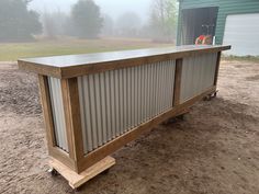 a metal and wood bar on wheels in the dirt