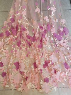 pink and purple flowers are attached to the sheer fabric